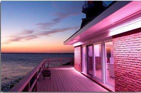 A House With Pink Lights On The Side Of The Deck