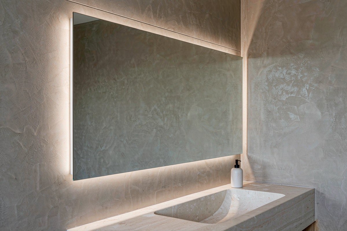 Render of a bathroom vanity with a frameless mirror and a concealed linear LED line