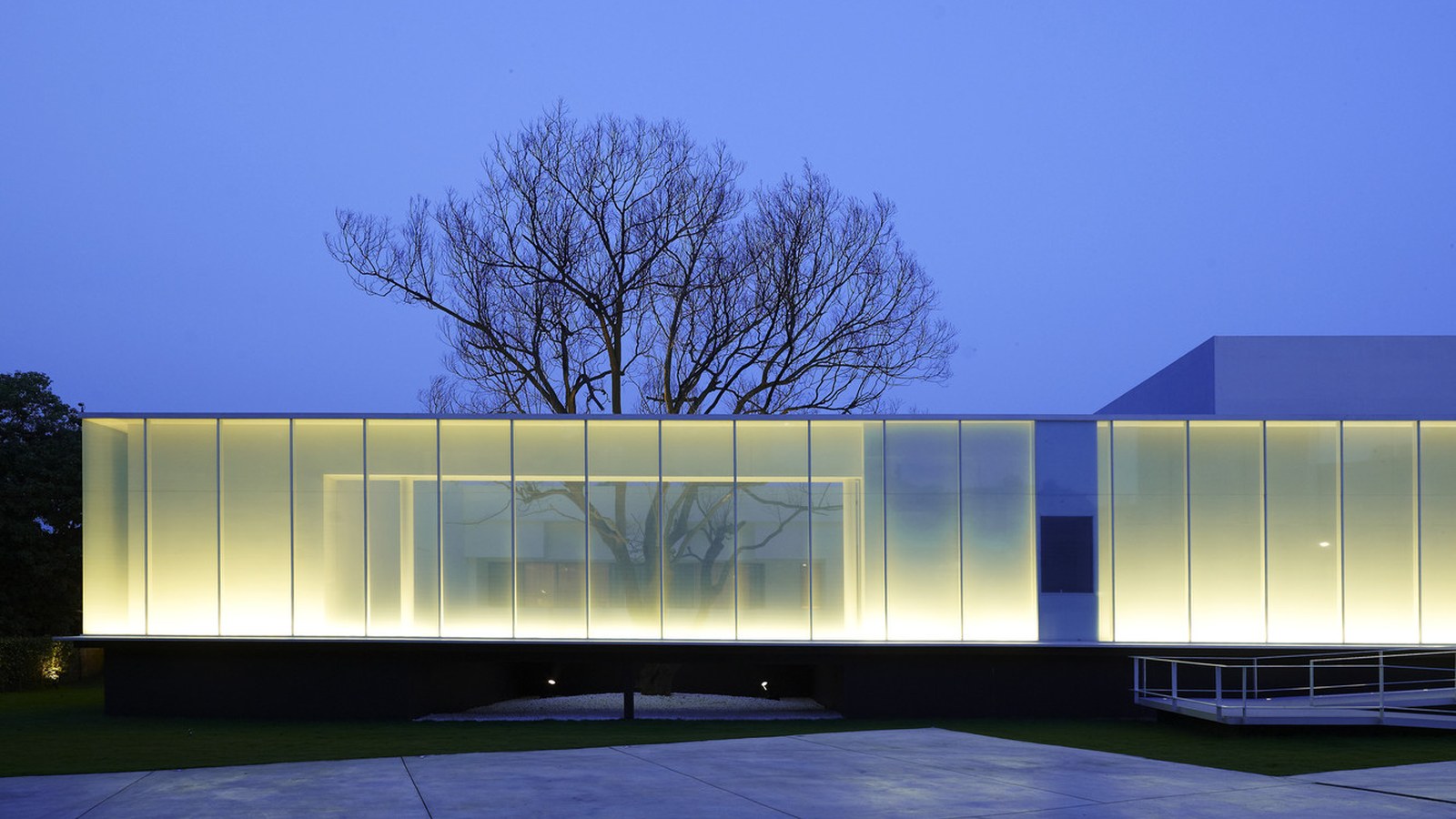 Continuous line of light under a building canopy washing the wall above