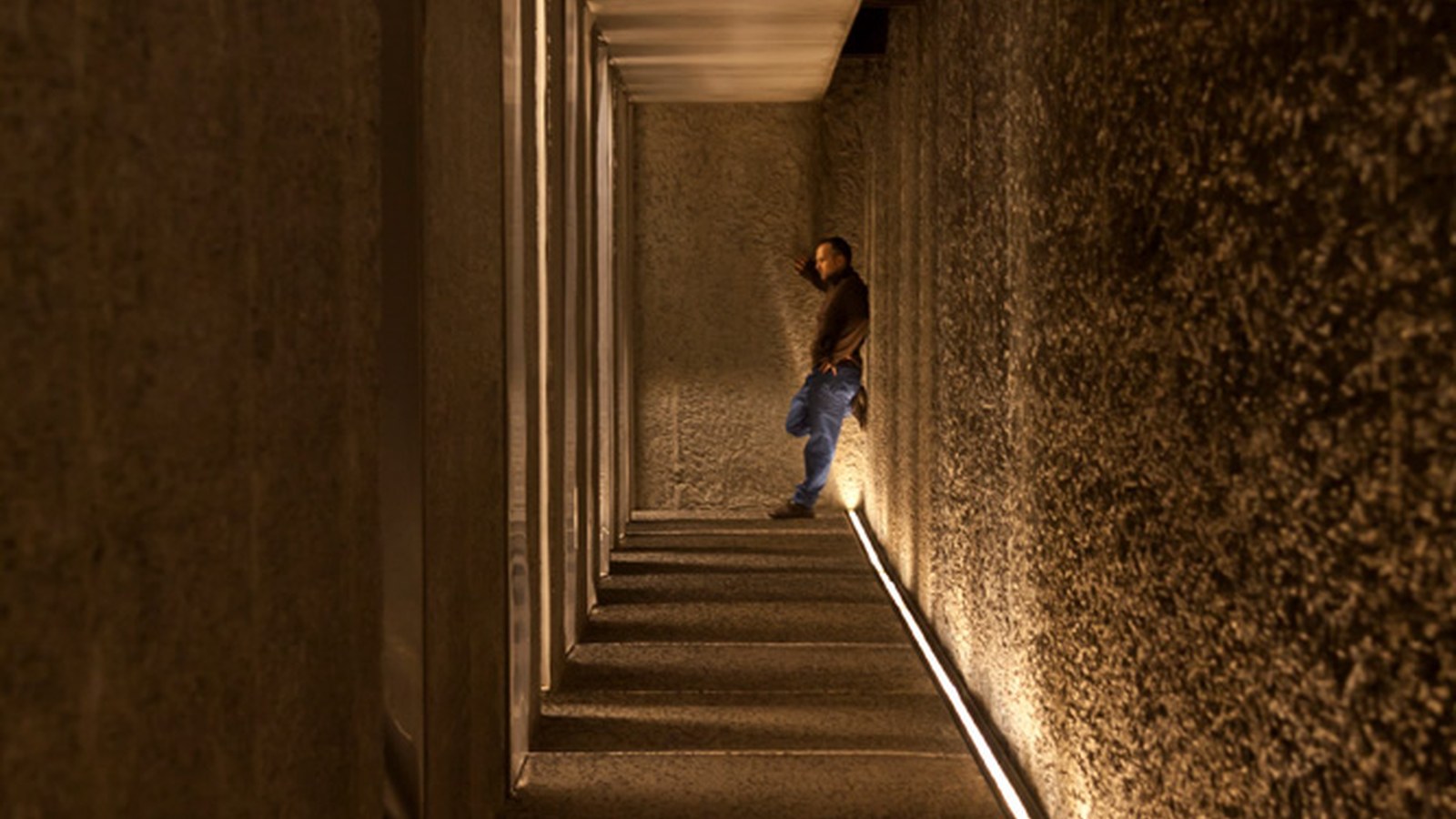 Corridor and stair wall lit by a continuous linear wall washer