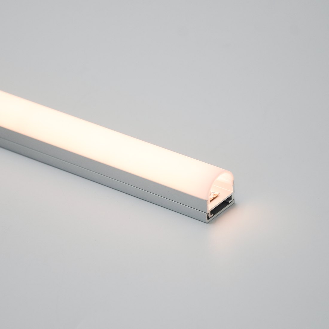 Wide aluminum body lit by one narrow strip, showing part of the diffuser staying dark